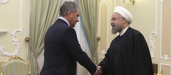 President Hassan Rouhani, right, shakes hands with Russian Defence Minister Sergei Shoigu at the start of their meeting in Tehran, Iran - Sputnik International