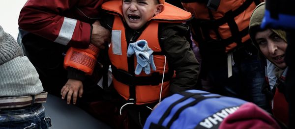 A child reacts as refugees and migrants disembark a rubber boat upon arrival at the northern island of Lesbos after crossing the Aegean sea from Turkey, in Mytilene, on February 23, 2016. A child reacts as refugees and migrants disembark a rubber boat upon arrival at the northern island of Lesbos after crossing the Aegean sea from Turkey, in Mytilene, on February 23, 2016. - Sputnik International