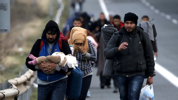Refugees carry their children through a national motorway towards the Greek-Macedonian border near the Greek town of Polykastro. - Sputnik International