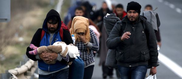 Refugees carry their children through a national motorway towards the Greek-Macedonian border near the Greek town of Polykastro. - Sputnik International