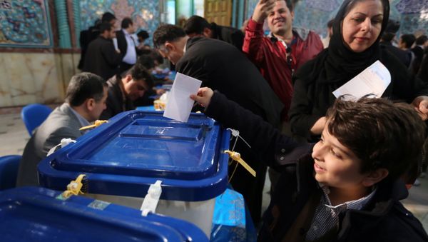 An Iranian boy casts his father ballot for both parliamentary elections and the Assembly of Experts at a polling station in Tehran on February 26, 2016 An Iranian boy casts his father ballot for both parliamentary elections and the Assembly of Experts at a polling station in Tehran on February 26, 2016 - Sputnik International