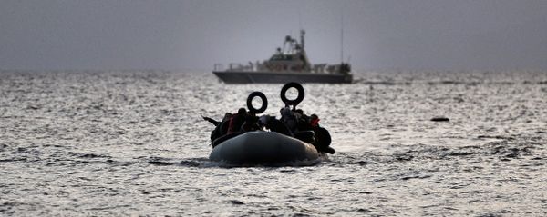 Refugees and migrants on a dinghy approach Mytilene on the northern island of Lesbos after crossing the Aegean sea from Turkey on February 19, 2016 - Sputnik International