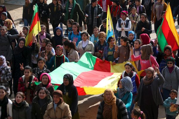 Kurdish people carry flags as they march during a protest in the city of al-Derbasiyah, on the Syrian-Turkish border, against what the protesters said were the operations launched in Turkey by government security forces against the Kurds, February 9, 2016 - Sputnik International