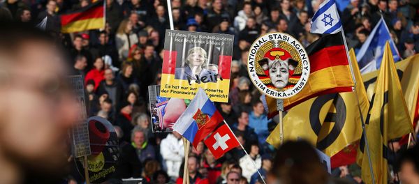 Supporters of the anti-Islam movement Patriotic Europeans Against the Islamisation of the West (PEGIDA) hold posters depicting German Chancellor Angela Merkel during a demonstration in Dresden, Germany, February 6, 2016 - Sputnik International