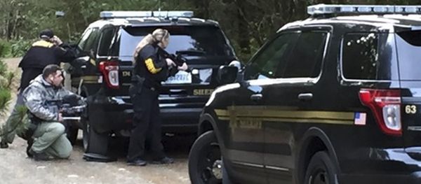 Police officers take cover behind vehicles lining the road during a standoff at a rural property near Belfair, Washington, February 26, 2016 - Sputnik International