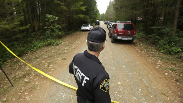 Mason County Sheriff's Chief Criminal Deputy Russ Osterhout looks down a road near the scene of a fatal shooting Friday, Feb. 26, 2016, near Belfair, Wash. - Sputnik International