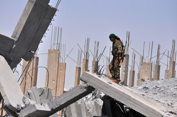 A female fighter from the Kurdish People Protection Unit (YPG) looks at destruction in the Syrian town of Ain Issi, some 50 kilometres north of Raqqa (File) A female fighter from the Kurdish People Protection Unit (YPG) looks at destruction in the Syrian town of Ain Issi, some 50 kilometres north of Raqqa (File) - Sputnik International
