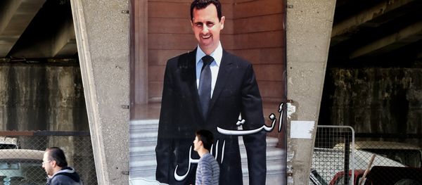 Syrian men walk past a poster bearing a portrait of President Bashar al-Assad in the capital Damascus, on February 27, 2016, as the first major ceasefire of the five-year war takes hold and an international task force prepares to begin monitoring the landmark truce - Sputnik International