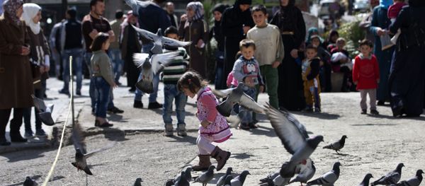 A Syrian girl chases pigeons in Marjeh Square, in Damascus, Syria, Saturday, Feb. 27, 2016 - Sputnik International