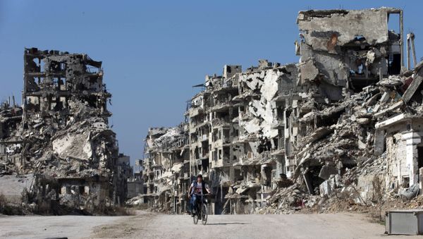 A Syrian boy rides a bicycle through a devastated part of the old city of Homs, Syria, Friday, Feb. 26, 2016 - Sputnik International