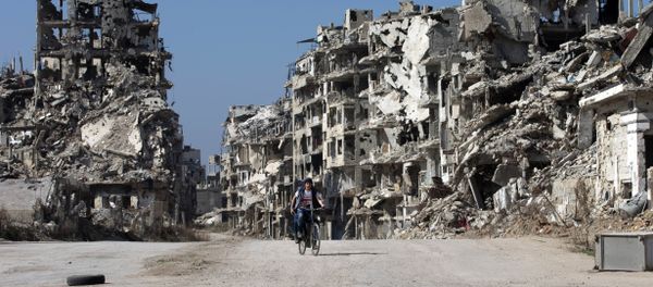 A Syrian boy rides a bicycle through a devastated part of the old city of Homs, Syria, Friday, Feb. 26, 2016 - Sputnik International