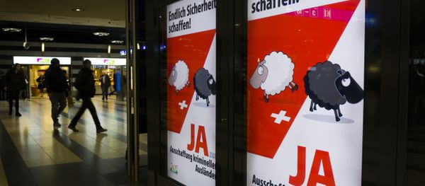 People walk past backlit posters of the right-wing populist Swiss People's Party (SVP) that translate from German as Finally Create Security to advertise their initiative for the eviction of criminal foreigners in Zurich on February 25, 2016 - Sputnik International