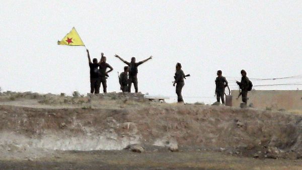 In this Monday, June 15, 2015 file photo taken from the Turkish side of the border between Turkey and Syria, in Akcakale, southeastern Turkey, Kurdish fighters with the Kurdish People's Protection Units, or YPG, wave their yellow triangular flag in the outskirts of Tal Abyad, Syria In this Monday, June 15, 2015 file photo taken from the Turkish side of the border between Turkey and Syria, in Akcakale, southeastern Turkey, Kurdish fighters with the Kurdish People's Protection Units, or YPG, wave their yellow triangular flag in the outskirts of Tal Abyad, Syria - Sputnik International