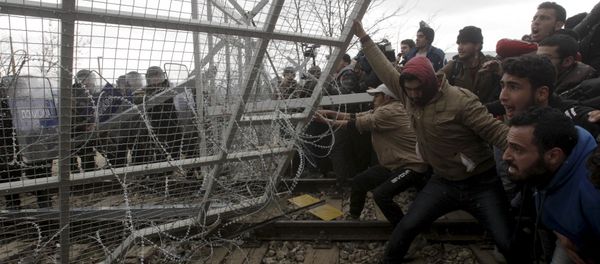 Stranded refugees and migrants try to bring down part of the border fence during a protest at the Greek-Macedonian border, near the Greek village of Idomeni, February 29, 2016 Stranded refugees and migrants try to bring down part of the border fence during a protest at the Greek-Macedonian border, near the Greek village of Idomeni, February 29, 2016 - Sputnik International