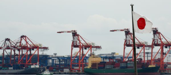 A Japanese national flag is seen in the foreground as international freighters are docked in Tokyo port on June 8, 2015 - Sputnik International