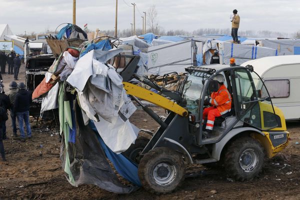 A bulldozer clears away debris from makeshift shelters. - Sputnik International