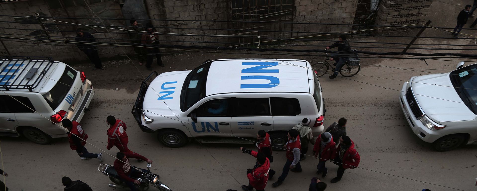 UN vehicles escorting a Red Crescent convoy carrying humanitarian aid arrive in Kafr Batna, in the rebel-held Eastern Ghouta area, on the outskirts of the capital Damascus on February 23, 2016 during an operation in cooperation with the UN to deliver aid to thousands of besieged Syrians. UN vehicles escorting a Red Crescent convoy carrying humanitarian aid arrive in Kafr Batna, in the rebel-held Eastern Ghouta area, on the outskirts of the capital Damascus on February 23, 2016 during an operation in cooperation with the UN to deliver aid to thousands of besieged Syrians. - Sputnik International, 1920, 12.07.2022