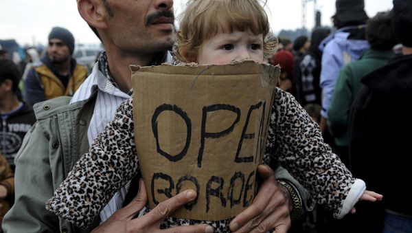 A stranded refugee holds a child during a protest at the Greek-Macedonian border as they wait for the border crossing to reopen near the Greek village of Idomeni, February 28, 2016. A stranded refugee holds a child during a protest at the Greek-Macedonian border as they wait for the border crossing to reopen near the Greek village of Idomeni, February 28, 2016. - Sputnik International