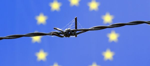 A barbed wire is seen in front of European Union flag - Sputnik International