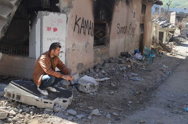 A resident of Cizre sits next to his ruined and burned house. - Sputnik International