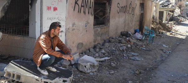 A resident of Cizre sits next to his ruined and burned house. - Sputnik International