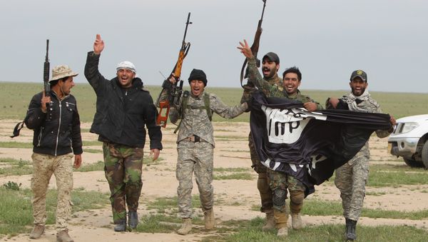 Iraqi Shiite fighters from the Popular Mobilisation units carry an Islamic State (IS) group flag on March 3, 2016, during an operation in the desert of Samarra aimed at retaking areas from IS jihadists - Sputnik International
