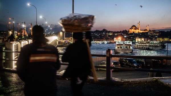 A vendor passes Galata Bridge near the illuminated Suleymaniye mosque in Istanbul on January 25, 2016 A vendor passes Galata Bridge near the illuminated Suleymaniye mosque in Istanbul on January 25, 2016 - Sputnik International