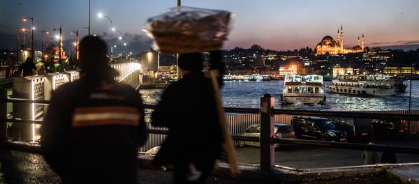 A vendor passes Galata Bridge near the illuminated Suleymaniye mosque in Istanbul on January 25, 2016 - Sputnik International