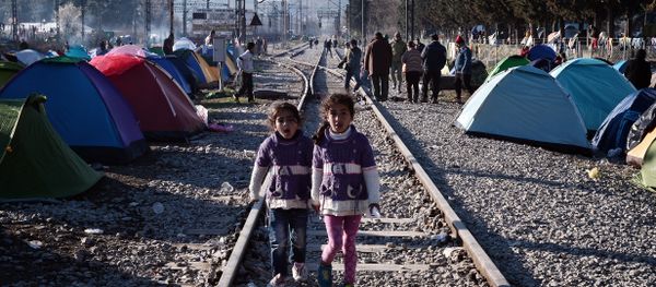 Sisters walk on railway tracks where refugees installed their tents at the makeshift camp of the Greek-Macedonian border near the Greek village of Idomeni, on March 5, 2016, where thousands of refugees and migrants wait to cross the border into Macedonia Sisters walk on railway tracks where refugees installed their tents at the makeshift camp of the Greek-Macedonian border near the Greek village of Idomeni, on March 5, 2016, where thousands of refugees and migrants wait to cross the border into Macedonia - Sputnik International