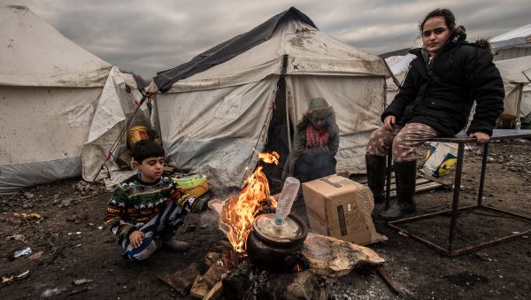 Young migrants get warm around a brazier in the migrants camp of Grande-Synthe, near Dunkirk, on January 20, 2016, where almost some 2,500 migrants and refugees live, mostly Iraqi Kurds and Syryans Young migrants get warm around a brazier in the migrants camp of Grande-Synthe, near Dunkirk, on January 20, 2016, where almost some 2,500 migrants and refugees live, mostly Iraqi Kurds and Syryans - Sputnik International