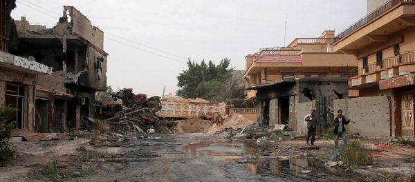 Two men walked beside destroyed buildings after clashes between military forces loyal to Libya's eastern government and Islamist fighters, in Benghazi, Libya, February 28, 2016 Two men walked beside destroyed buildings after clashes between military forces loyal to Libya's eastern government and Islamist fighters, in Benghazi, Libya, February 28, 2016 - Sputnik International