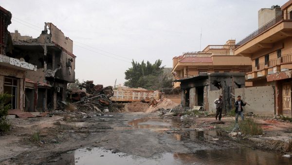 Two men walked beside destroyed buildings after clashes between military forces loyal to Libya's eastern government and Islamist fighters, in Benghazi, Libya, February 28, 2016 Two men walked beside destroyed buildings after clashes between military forces loyal to Libya's eastern government and Islamist fighters, in Benghazi, Libya, February 28, 2016 - Sputnik International