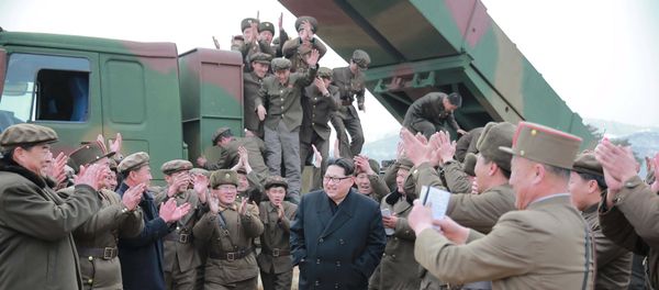 North Korean leader Kim Jong Un (C) smiles as he guides a test fire of a new multiple launch rocket system in this undated photo released by North Korea's Korean Central News Agency (KCNA) in Pyongyang March 4, 2016 - Sputnik International