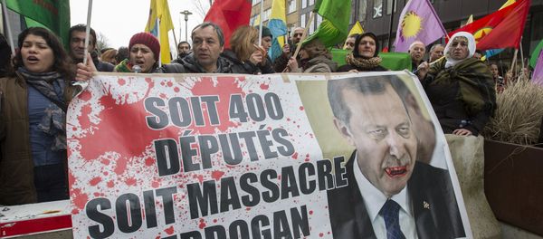 Kurdish people display a picture of Turkish President Tayyip Erdogan during a protest outside an EU-Turkey summit as the bloc is looking to Ankara to help it curb the influx of refugees and migrants flowing into Europe, in Brussels March 7, 2016 - Sputnik International