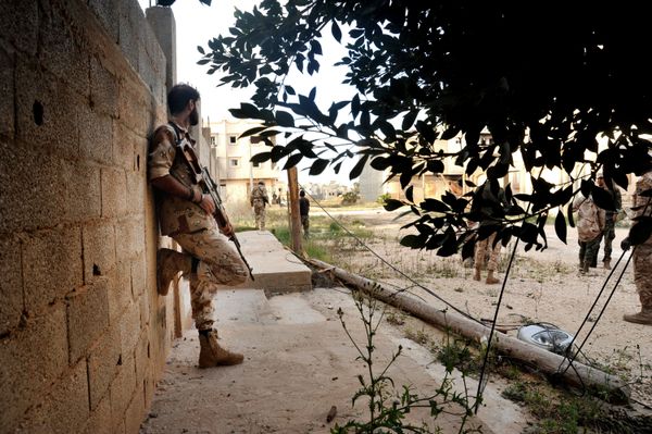 In this Monday, March 7, 2016 photo, men loyal to Libyan armed forces stand alert during clashes with Islamic State group militants west of Benghazi, Libya - Sputnik International