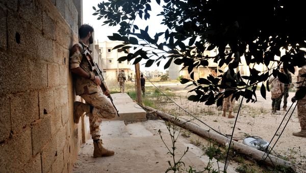 In this Monday, March 7, 2016 photo, men loyal to Libyan armed forces stand alert during clashes with Islamic State group militants west of Benghazi, Libya In this Monday, March 7, 2016 photo, men loyal to Libyan armed forces stand alert during clashes with Islamic State group militants west of Benghazi, Libya - Sputnik International