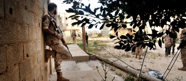 In this Monday, March 7, 2016 photo, men loyal to Libyan armed forces stand alert during clashes with Islamic State group militants west of Benghazi, Libya - Sputnik International