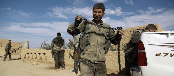 A fighter from the Syrian Democratic Forces (SDF) carries an empty ammunition belt upon his return from clashes in the town of al-Shadadi in the northeastern Syrian province of Hasakeh, on February 19, 2016 A fighter from the Syrian Democratic Forces (SDF) carries an empty ammunition belt upon his return from clashes in the town of al-Shadadi in the northeastern Syrian province of Hasakeh, on February 19, 2016 - Sputnik International