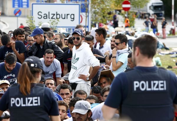 German police officers standing in front of migrants waiting to cross the border from Austria to Germany near Freilassing, Germany September 17, 2015. German police officers standing in front of migrants waiting to cross the border from Austria to Germany near Freilassing, Germany September 17, 2015. - Sputnik International