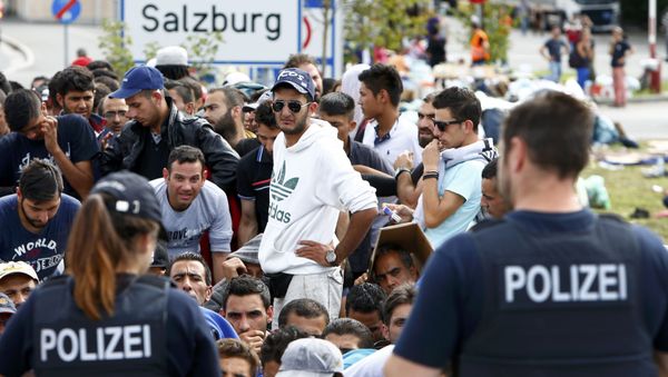 German police officers standing in front of migrants waiting to cross the border from Austria to Germany near Freilassing, Germany September 17, 2015. - Sputnik International