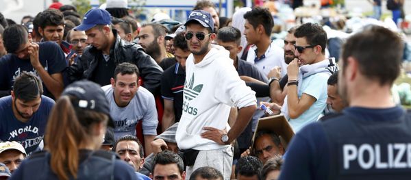 German police officers standing in front of migrants waiting to cross the border from Austria to Germany near Freilassing, Germany September 17, 2015. - Sputnik International