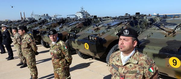 Italian Army soldiers stand by some of the twenty military vehicles during an handing over ceremony by Italy to Libya at a Libyan Navy Base on February 6, 2013 in Tripoli. - Sputnik International
