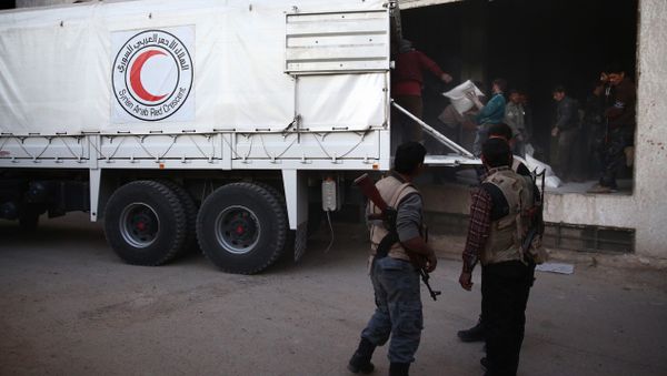 Syrian rebel fighters stand guard as sacs of aid are unloaded from a Syrian Arab Red Crescent truck in Hammuriya, in the eastern Ghouta region, a rebel stronghold east of the Syrian capital Damascus during a UN-led operation to deliver food and medical supplies Syrian rebel fighters stand guard as sacs of aid are unloaded from a Syrian Arab Red Crescent truck in Hammuriya, in the eastern Ghouta region, a rebel stronghold east of the Syrian capital Damascus during a UN-led operation to deliver food and medical supplies - Sputnik International