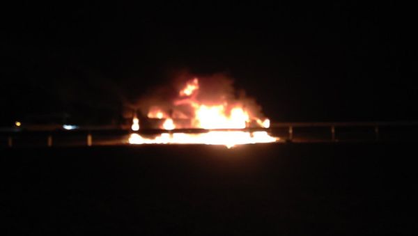 A small bus on fire which was carrying foreign and Russian journalists, and activists from a non-governmental organization, is seen after been attacked near the border of Chechnya by men in Ingushetia, South Russia, Wednesday, March 9, 2016. - Sputnik International