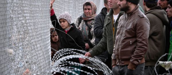 People look at the Macedonian side of the border through a fence in the makeshift camp at the Greek-Macedonian border near the Greek village of Idomeni, on March 3, 2016. People look at the Macedonian side of the border through a fence in the makeshift camp at the Greek-Macedonian border near the Greek village of Idomeni, on March 3, 2016. - Sputnik International