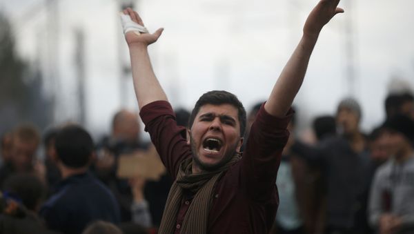 A migrant shouts slogans as he is blocking the railway track at the Greek-Macedonian border, near the village of Idomenii, Greece March 12, 2016. - Sputnik International
