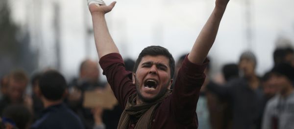 A migrant shouts slogans as he is blocking the railway track at the Greek-Macedonian border, near the village of Idomenii, Greece March 12, 2016. A migrant shouts slogans as he is blocking the railway track at the Greek-Macedonian border, near the village of Idomenii, Greece March 12, 2016. - Sputnik International