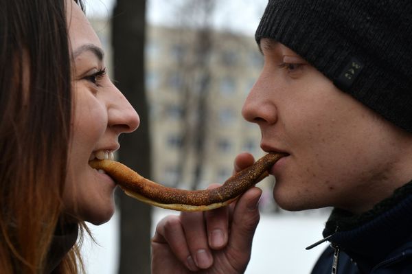 Young people eat pancakes at the Shirokaya Maslenitsa 2016 festival in Kazan Young people eat pancakes at the Shirokaya Maslenitsa 2016 festival in Kazan - Sputnik International