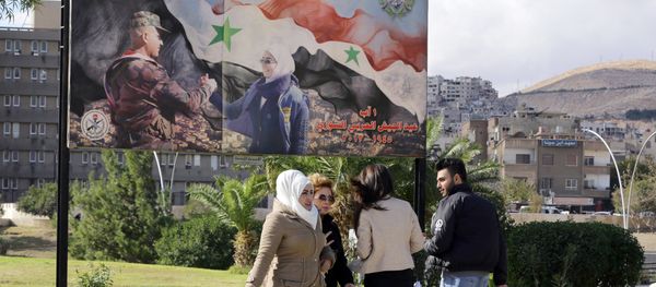 Syrians walk past a billboard bearing a national flag and a slogan which reads in Arabic You are the future and long live the country in Damascus on December 2, 2015 Syrians walk past a billboard bearing a national flag and a slogan which reads in Arabic You are the future and long live the country in Damascus on December 2, 2015 - Sputnik International