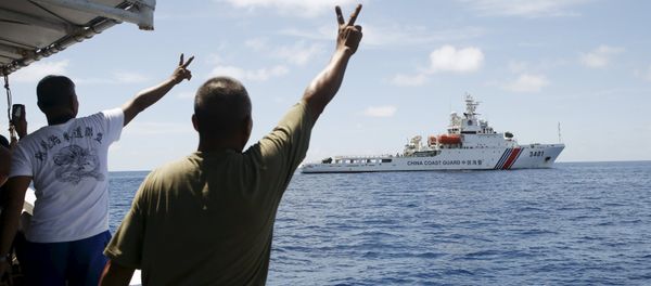 Filipino soldiers gesture at a Chinese Coast Guard vessel on the disputed Second Thomas Shoal, part of the Spratly Islands, in the South China Sea March 29, 2014 - Sputnik International